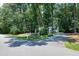 Charming home nestled among lush trees, with a well-manicured front yard and long driveway at 608 Misty Isle Pl, Raleigh, NC 27615