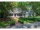 Inviting white home with a brick path, surrounded by lush trees for enhanced privacy and classic elegance at 608 Misty Isle Pl, Raleigh, NC 27615