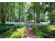 Beautiful landscaped yard with a brick pathway leading to a charming home, showcasing meticulous maintenance and care at 608 Misty Isle Pl, Raleigh, NC 27615