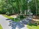 Landscaped front yard view of a quaint house nestled among mature trees in a lovely neighborhood at 608 Misty Isle Pl, Raleigh, NC 27615
