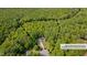 Aerial view of a home nestled within a lush, green, densely wooded area at 62 Mountain Laurel Ln, Four Oaks, NC 27524