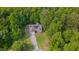 Aerial view of home featuring a manicured lawn and a driveway leading to a garage and solar panels at 62 Mountain Laurel Ln, Four Oaks, NC 27524
