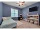 Blue bedroom with natural light, a twin bed, TV, and a bookcase at 62 Mountain Laurel Ln, Four Oaks, NC 27524