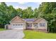 Charming single-story home with neutral siding, stone accents, and an attached two-car garage at 62 Mountain Laurel Ln, Four Oaks, NC 27524