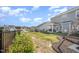Landscaped backyard featuring a covered patio, black fence, and colorful flower garden on a sunny day at 645 Longstanton Ave, Zebulon, NC 27597