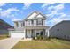 Beautiful two-story home with gray siding, white trim, and a well-manicured lawn at 645 Longstanton Ave, Zebulon, NC 27597