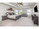 Bright main bedroom with a tray ceiling, ceiling fan, and a sitting area by the windows at 645 Longstanton Ave, Zebulon, NC 27597