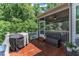 Outdoor deck with a grill, a storage box and a view of the yard and trees at 6509 Conaway Ct, Wake Forest, NC 27587