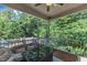 Relaxing screened porch with cozy seating, table, and serene view of lush trees at 6509 Conaway Ct, Wake Forest, NC 27587