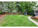 Lush backyard featuring a wooden fence, a cozy fire pit area, and a deck perfect for outdoor entertaining at 709 Bonhurst Dr, Holly Springs, NC 27540