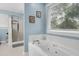 Bright bathroom featuring a deep soaking tub with jets and separate glass shower at 709 Bonhurst Dr, Holly Springs, NC 27540