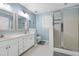 Light and airy bathroom featuring double sinks, a glass enclosed shower, and tile flooring at 709 Bonhurst Dr, Holly Springs, NC 27540