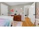 Bedroom with hardwood floors, wainscotting, and a view into the hallway at 709 Bonhurst Dr, Holly Springs, NC 27540