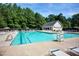 Community pool surrounded by lush trees and lounge chairs at 709 Bonhurst Dr, Holly Springs, NC 27540