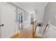 Upstairs hallway with hardwood floors and wainscoting leads to bedrooms and living spaces at 709 Bonhurst Dr, Holly Springs, NC 27540