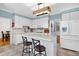 Well-lit kitchen with white cabinetry, stainless appliances, and breakfast bar seating at 709 Bonhurst Dr, Holly Springs, NC 27540