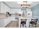 Charming kitchen features white cabinets, updated appliances, and tiled backsplash at 709 Bonhurst Dr, Holly Springs, NC 27540