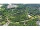 Aerial view shows heavily wooded lot outlined in white with nearby community at 7104 Camp Branch Ln, Apex, NC 27502