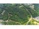 Aerial view shows heavily wooded lot with water and nearby community at 7104 Camp Branch Ln, Apex, NC 27502