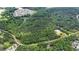 Aerial view shows heavily wooded lot with water and nearby community at 7104 Camp Branch Ln, Apex, NC 27502