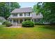 Traditional two-story home with front porch and black shutters surrounded by lush greenery at 7104 Camp Branch Ln, Apex, NC 27502