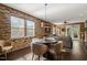Dining area featuring a round table, chairs, and brick accent wall near the living room and kitchen at 744 Birch Arbor Cir, Raleigh, NC 27604