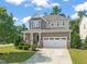 Inviting two-story home with a well-manicured lawn, stone accents, and a two-car garage, enhancing curb appeal at 744 Birch Arbor Cir, Raleigh, NC 27604