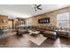 Spacious living area featuring a leather sectional sofa and a decorative brick accent wall at 744 Birch Arbor Cir, Raleigh, NC 27604