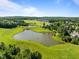 Panoramic aerial shot showcasing a picturesque pond, golf course, and stunning homes within a vibrant community at 98 Stone Bridge Xing # 98, Chapel Hill, NC 27517