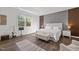 Bright main bedroom featuring tray ceiling, wood accent walls, and large windows at 98 Stone Bridge Xing # 98, Chapel Hill, NC 27517