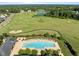 Aerial view featuring a dazzling pool and adjacent golf course, exemplifying luxurious community amenities at 98 Stone Bridge Xing # 98, Chapel Hill, NC 27517