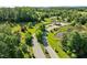 Aerial view of the community entrance featuring lush landscaping, trees, a pond, and manicured lawns at 98 Stone Bridge Xing # 98, Chapel Hill, NC 27517