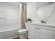 Bright bathroom featuring a white vanity, round mirror, and a tub-shower combo at 1006 E Harnett St, Dunn, NC 28334
