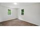 Sunny bedroom with wood-look flooring, fresh paint and ample natural light through two windows at 1006 E Harnett St, Dunn, NC 28334