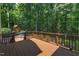 An expansive back deck overlooks a lush, wooded backyard and a playhouse at 104 Bellagio Dr, Apex, NC 27539