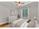 Bright bedroom showcasing a large window, ceiling fan, and neutral tones at 104 Bellagio Dr, Apex, NC 27539