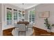 Sunlit dining room with wainscoting features a round table and large windows at 104 Bellagio Dr, Apex, NC 27539