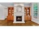 Close-up of fireplace with stone surround, built-in bookcases, and hardwood floors at 104 Bellagio Dr, Apex, NC 27539