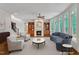 Spacious living room with fireplace, built-in bookcases, large windows, and hardwood floors at 104 Bellagio Dr, Apex, NC 27539