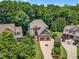 Beautiful aerial view of a two-story home featuring a two-car garage and lush landscaping in a desirable neighborhood at 104 Bellagio Dr, Apex, NC 27539