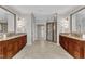 Bright bathroom with double vanities, walk-in shower, and access to the walk-in closet at 104 Bellagio Dr, Apex, NC 27539