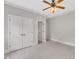 Neutral carpeted bedroom with double closets, ceiling fan and crown moulding at 104 Bellagio Dr, Apex, NC 27539