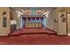 Bonus room with elevated seating, custom built-in bar, and elegant draperies at 104 Bellagio Dr, Apex, NC 27539