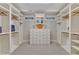 Spacious walk-in closet with custom shelves, drawers, and window bringing in natural light at 104 Bellagio Dr, Apex, NC 27539