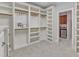 Custom walk-in closet with built-in shelving, drawers, and easy access to the kitchenette at 104 Bellagio Dr, Apex, NC 27539