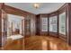 A den with hardwood floors, paneled walls, french doors and light from bay windows at 104 Bellagio Dr, Apex, NC 27539