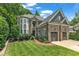 Charming stone home featuring a well-kept lawn and lovely landscaping at 104 Bellagio Dr, Apex, NC 27539