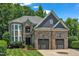Elegant stone house with a circular window and attached two-car garage at 104 Bellagio Dr, Apex, NC 27539