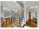 A grand foyer with hardwood floors, staircase with iron railings, and views into adjacent rooms at 104 Bellagio Dr, Apex, NC 27539