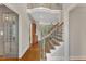 An open foyer with hardwood floors, decorative staircase, and views into the Gathering room and living spaces at 104 Bellagio Dr, Apex, NC 27539